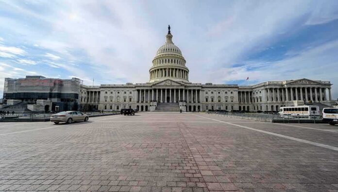 shutterstock_1676991334 United States Capitol building with dome under a partly cloudy sky