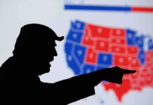 Iowa, Ohio and Kansas Senate Races Remain Close silhouetted person pointing in front of a U.S. election map