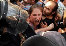 Protesters clash with riot police as woman shouts