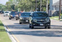Storms Force Trump’s High-Speed Dash motorcade of black SUVs driving down a suburban street