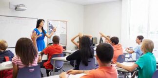 NYC School Teacher Faces Backlash Over Social Media Post Teacher leading classroom discussion with students raising hands