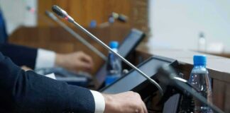 Person pressing a button on a conference microphone panel
