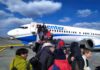 Passengers boarding a commercial airplane via mobile stairs