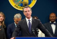 Gavin Newsom speaks at a podium with microphones during a press conference