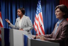 Terrorism Allegations Shake Senate Race Two women at podiums during a debate with U.S. flags behind them