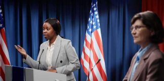 Terrorism Allegations Shake Senate Race Two women at podiums during a debate with U.S. flags behind them