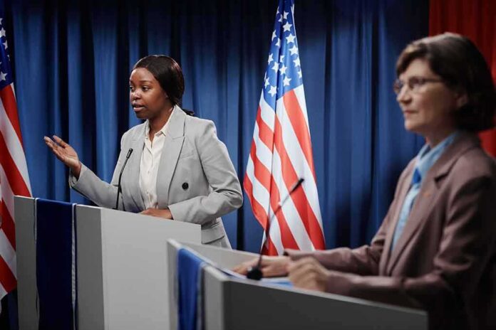 shutterstock_2453038563 Two women at podiums during a debate with U.S. flags behind them