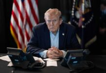Trump Shifts Ads to Private Funding Donald Trump seated at a table between two desk phones
