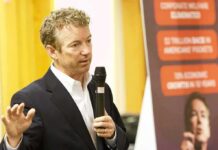 Rand Paul speaking with a microphone during an indoor event