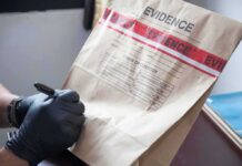 Florida Robbery Suspect Accused of Wearing Old-Man Mask Gloved hands labeling a sealed evidence bag