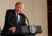 Donald Trump speaking at a podium with presidential seal