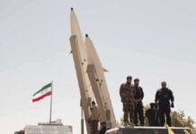 Trump Makes Bold Claims on Iran and Ukraine Soldiers stand beside large missiles at an outdoor display